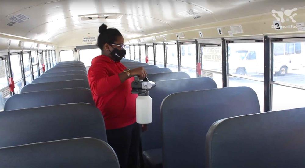 Electrostatic sprayer disinfecting a bus
