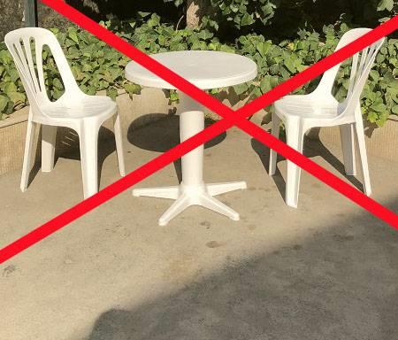 دو عدد صندلی پلاستکی معمولی به همراه میز دونفره پلاستیکی معمولی نامناسب برای فضای باز